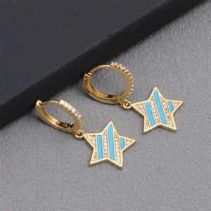 Detail of gold hoop earrings featuring blue enamel star pendants with micro zircon stones