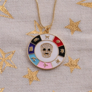 Detail of gold-plated necklace with enamel skull pendant and zircon accents on linen