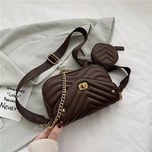 Detail of dark brown quilted crossbody bag with gold twist lock and round coin purse