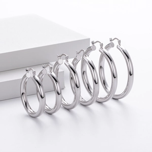 Detailed comparison of three polished silver hoop earrings in different sizes on white backdrop