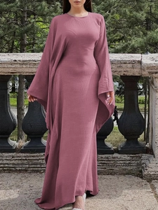 Élégante robe longue rose à manches longues avec texture plissée présentée dans un parc extérieur