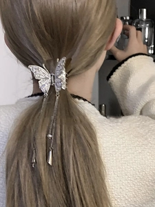 Silver butterfly hair claw clip with rhinestones and long tassel on model ponytail