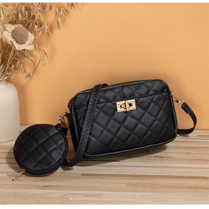 Detalle del bolso bandolera acolchado negro con cierre dorado y mini monedero redondo