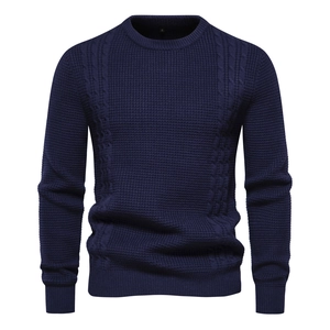 Detail of dark blue crewneck sweater with waffle texture and cable knit patterns