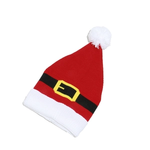 Close-up of knit Santa hat featuring white pompom and black belt buckle design