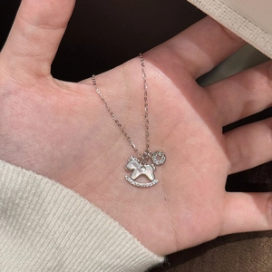 Vue détaillée d'un collier pendentif cheval à bascule en argent avec des zircons