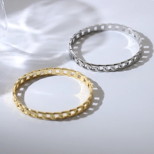 Detailed view of punk style chain-link bangle in polished gold and silver steel finish