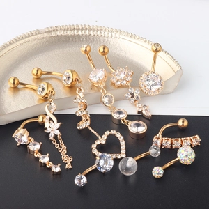 Close-up of gold-plated navel rings set featuring sparkling zircon and heart shapes