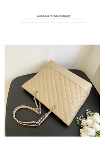 Detailed macro view of beige diamond-quilted calfskin leather with luxury metal chain strap