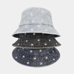 Three colors of denim bucket hats with daisy embroidery in blue and grey washes