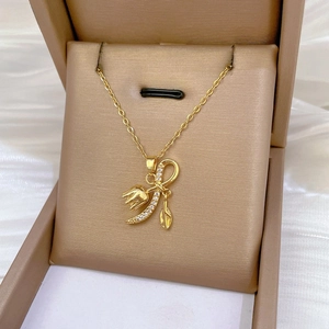 Detail of gold tulip bellflower necklace with sparkling zircon and feather pendant
