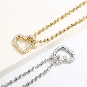 Close-up of gold and silver heart-shaped pendants with small diamonds on bead chains