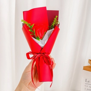 Detail of hand holding a single red soap rose bouquet with Happy Everyday ribbon decoration