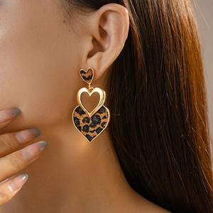 Close-up of triple layered leopard print heart earrings on model for a vintage look