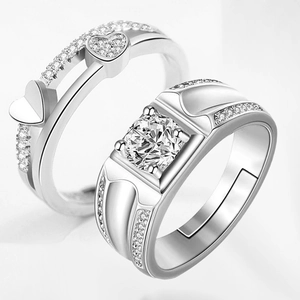Macro shot of silver couples rings featuring heart patterns and sparkling zircon stones