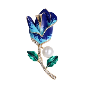 Detail view of gold rose brooch with blue enamel petals, white pearl and sparkling crystals