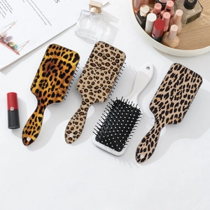 Set of four stylish leopard print cushion hairbrushes arranged with fashion accessories