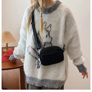 Sac bandoulière minimaliste noir en nylon avec sangle et breloque ours à damier