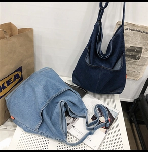 Close-up of dual-tone washed denim tote bags with large front pockets and shoulder straps