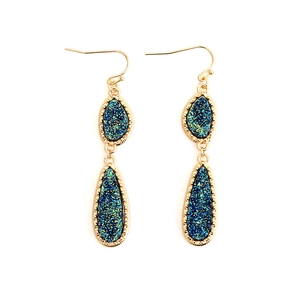 Detail of drop earrings featuring gold metal borders and teal crystalline druzy stones