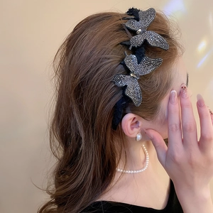 Detail of luxurious rhinestone butterfly hair clip with shimmering black layered wings