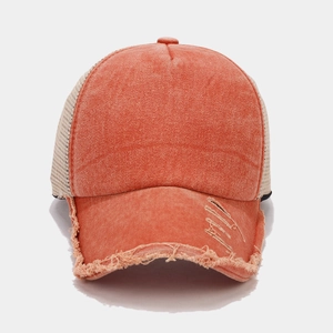 Dettaglio del cappello trucker arancione con visiera consumata e rete traspirante beige