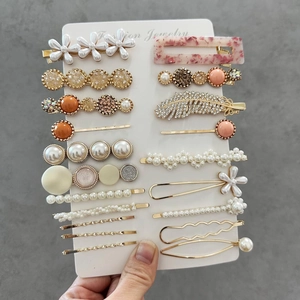 Detail of multi-piece acetate hair clip set with marble patterns and pearls on card