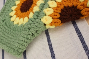 Close-up of handmade crochet sunflower bag showing intricate yarn texture and stitching
