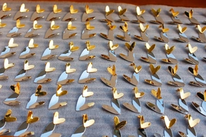 Detail view of heart-shaped earrings with gold and silver two-tone mirror finish