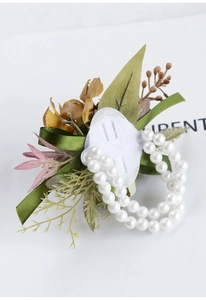 Detail of silk corsage wristlet with yellow flower, green ribbon, and pearl bracelet