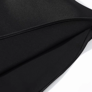 Gros plan sur la texture en satin noir et les coutures précises de ce chemisier en dentelle