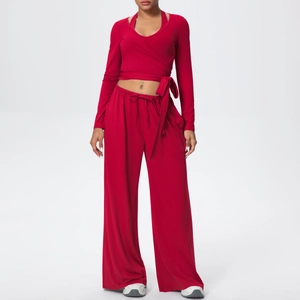 Détail d'un haut cache-cœur rouge à manches longues et d'un pantalon de yoga large