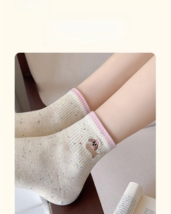 Detail of breathable cream cotton socks with colorful dots and a cute dog embroidery