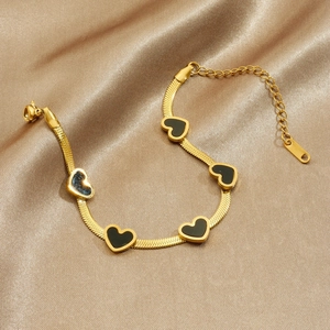 Gold-plated blade chain bracelet featuring five black enamel heart charms on silk fabric