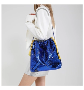 Detail of royal blue sequined bucket bag with contrasting yellow drawstring and chain strap