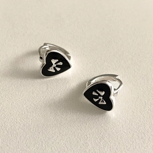 Detail of 925 sterling silver heart earrings with black enamel and bow motif