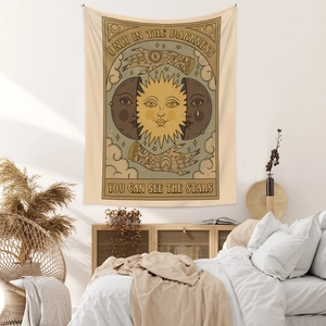 Detail of bohemian sun and moon tapestry with inspirational quote on a bedroom wall