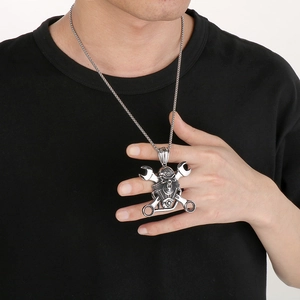 Detail of punk skeleton pendant with wrenches and mechanical elements on black shirt