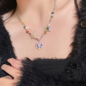 Detail of Y2K style necklace with purple heart pendant and colorful translucent beads