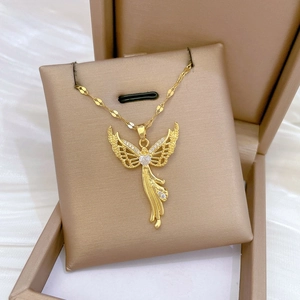 Macro detail of gold angel pendant featuring sparkling zircon wings and heart-shaped stone