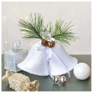 Detail of glittery white Christmas bells with faux pine needles and pine cones