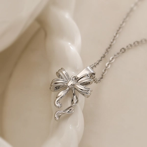 Minimalist silver bow pendant necklace for women with high-gloss metallic finish