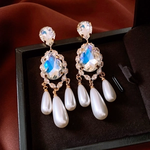 Close-up of 18k gold plated water drop earrings with pearls on dark silk background