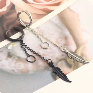Detail of silver and black feather tassel earrings with metal rings and chains