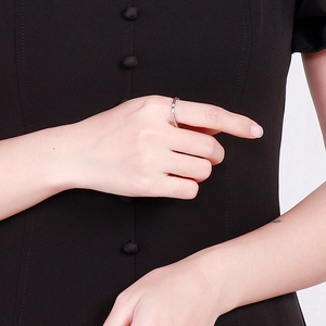 Minimalist square silver ring with small diamond on a woman hand with a dark dress