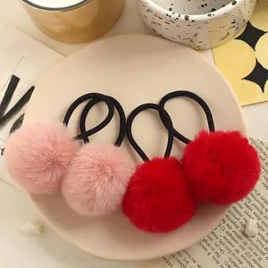 Set of four fluffy faux rabbit fur pom pom hair ties in soft pink and vibrant red colors