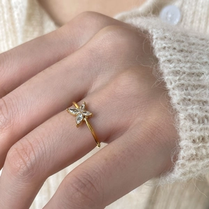 Macro view of a gold-tone butterfly ring with marquise-cut zircons worn on the finger