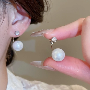Macro shot of silver stud earrings with sparkling cubic zirconia and white faux pearls