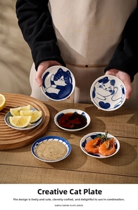 Macro view of blue and white ceramic cat-themed sauce dishes on a wooden table