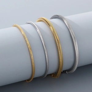 Detail of gold and silver snake bone chain bracelets on a professional display prop